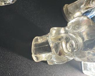 Clear Glass Puppy Figurine — This charming clear glass puppy figurine adds a whimsical touch to any collection or display. Crafted from translucent glass, it features smooth contours and detailed facial features capturing the playful essence of a puppy. Measuring approximately 3 inches tall and 2.5 inches wide, it is a delicate decorative accent perfect for shelves or desks. The figurine is in good condition with no visible chips or cracks. Ideal as a collectible or a gift item for animal lovers.