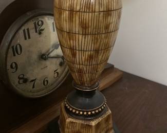 Table Lamp with Beige Shade — This rustic table lamp features a uniquely patterned wooden base with earthy brown tones and decorative accents. The lamp is topped with a beige fabric shade that softly diffuses light, making it ideal for a cozy bedroom setting. Measuring approximately 24 inches tall and 12 inches wide at the shade, it balances style and function perfectly. The lamp is in good condition with minor signs of use but fully functional. Its traditional design complements a variety of interior decor styles.