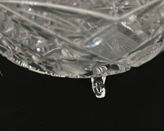 Crystal Bowl with Feet — This crystal bowl with feet is a beautifully crafted decorative piece featuring intricate cut glass patterns. The bowl is clear crystal with detailed floral and geometric cuts, creating a sparkling effect. It is designed with three sturdy crystal feet for stability and elegance. Measuring approximately 7 inches in diameter and 3.5 inches in height, it is perfect for display or serving. The item is in excellent condition with no chips or cracks visible.