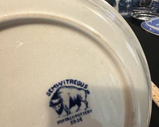 Buffalo Pottery Blue Willow bowl — This vintage Buffalo Pottery plate features the classic Blue Willow pattern in vibrant blue on a semivitreous ceramic base, dated 1941. The plate showcases intricate scenic designs with traditional border motifs characteristic of the Blue Willow style. Measuring approximately 10 inches in diameter, it is a fine example of early 20th-century American pottery. The plate is in good vintage condition with minor wear consistent with age and no visible cracks or chips. This collectible piece from Buffalo Pottery offers both historical charm and decorative appeal for collectors or enthusiasts of blue and white china.