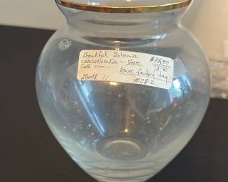 Bohemia Czechoslovakia Glass Vase — This beautiful Bohemia vase from Czechoslovakia features a delicate clear glass body accented with a gold rim. The rounded shape offers a classic and elegant look suitable for any master bedroom decor. It stands approximately 6 inches tall and 5 inches wide at its widest point, making it a versatile size for display. The vase is in good condition, with no visible chips or cracks, retaining the original gold trim. A lovely collectible from a renowned glassmaking region, perfect for adding vintage charm to your space.