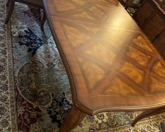 Dining Room Wood Inlaid Table & chairs — This elegant dining room table features a finely crafted wood surface with intricate inlaid diamond patterns. The table is supported by sturdy cabriole legs and comes with matching upholstered armchairs in a beige diamond pattern fabric. Measuring approximately 31 inches in height, 42 inches in width, and 90 inches in length, it offers ample seating for family and guests. The piece is in good condition with minor surface scratches consistent with normal use. Its classic design and quality woodwork make it a versatile addition to any traditional dining space.