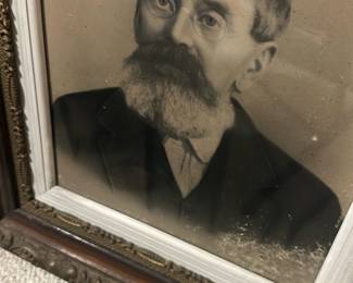 Ornate Oak Framed Portrait — Large framed portrait of a bearded gentleman in an ornate oak and gilt frame; the heavy carved molding and applied gilt ornament give this piece strong Victorian-era character. The portrait appears to be a charcoal or lithograph-style print behind original glass, set in a painted rabbet and decorative gilt liner. Overall substantial size (see dimensions) makes it well suited for a foyer or den; ideal for collectors of period frames or decorative salvage. Frame and print show surface grime, light spotting on the image, and some wear to the gilt and wood consistent with age but no major structural damage.