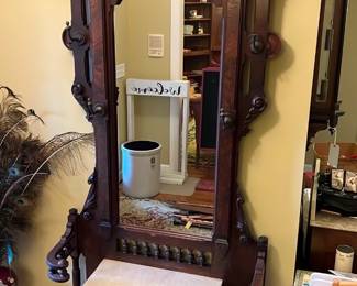 Victorian Mahogany Hall Tree Mirror — This stately Victorian hall tree mirror is crafted from rich mahogany featuring intricate carved design elements typical of the late 19th century. It includes a large rectangular mirror framed by detailed fretwork, finials, and turned spindles, along with a marble seat and a drawer underneath for storage. The piece measures approximately 82 inches in height, 40 inches in width, and 20 inches in depth, making it a prominent and functional entryway statement. The hall tree is in good condition with minor wear on the wood surface consistent with age, and the mirror remains clear without significant blemishes. This classic piece adds an elegant historic charm to any front room or entryway.