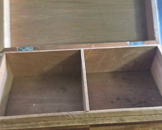 Vintage Wooden Inlay Jewelry Box — This vintage wooden jewelry box features intricate inlay work with a geometric border and a central motif of a dog figure. Constructed from wood with a hinged lid, the box is divided internally into two compartments, ideal for organizing small items. Measuring approximately 7 inches in length, 4 inches in width, and 3 inches in height, it offers a compact storage solution with a charming rustic appearance. The box shows some wear consistent with vintage use, adding to its character without compromising its integrity. Perfect for collectors of unique wooden boxes or vintage home decor items.