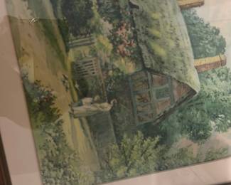Framed Cottage Watercolor Print — Framed watercolor-style print depicting an English cottage with thatched roof, garden, and a small statue in the foreground. Housed in a simple brown wood frame with off-white matting; artwork appears to be a reproduction print rather than an original painting. Frame measures approximately 26 inches wide by 20 inches tall and is lightweight enough for wall display. Glass has minor surface scratches and mat shows light age-toning, overall in good condition for resale at an estate sale.