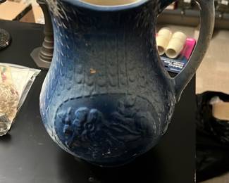 Clinahfeld Blue Floral Cream & Sugar — Pair of Clinahfeld (Clinahfeld Artware Pottery, Euvtn, Tenn.) blue floral ceramic creamer and covered sugar bowl from the Bonus Up Room. Both pieces have white glaze with hand-painted blue flowers and green leaves, blue sponged trim, and scalloped bases; sugar has a fitted lid. Overall small tableware size suitable for display or light use. Both show surface wear and residue on bases consistent with age and prior use but no obvious large chips or cracks visible in photos.