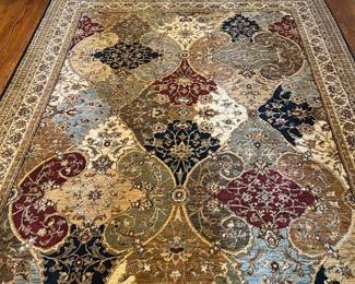 Shaw Rugs Multi-Color Area Rug  8 x11 — This Shaw Rugs multi-color area rug features a rich, intricate pattern in warm and cool tones including red, gold, blue, and black. Woven from 100% nylon pile, it offers durability and a soft texture underfoot, perfect for adding character to the dining room. Measuring precisely 2.3622 by 3.3782 meters (7'9"), it fits well in medium-sized spaces. The rug is in good condition with minimal wear and intact fringes. Made in the USA in 2002, this rug is a quality piece from a reputable manufacturer.