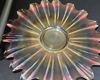 Carnival Glass Pink Ruffled Bowl — This vintage carnival glass bowl features a unique pink iridescent finish with a ruffled edge design. The pressed glass construction showcases sunburst ridges radiating from the center, creating a vibrant display of colors in light. Measuring approximately 8 inches in diameter, this bowl is ideal for decorative use or serving small items. It is in good vintage condition with minor surface wear consistent with age and use. A charming collectible piece that adds a nostalgic touch to any room or collection.