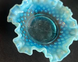 Fenton Hobnail Opalescent Bowl 5.75" — This charming Fenton hobnail opalescent bowl showcases the distinctive blue color with opalescent ruffled edges, a classic example of mid-20th century American art glass. Measuring 5 3/4 inches in diameter, the bowl features the iconic hobnail pattern typical of Fenton's collectible pieces. It is crafted from high-quality glass with excellent craftsmanship evident in its delicate ruffle and vibrant opacity. The bowl is in good condition with minor surface wear but no chips or cracks. A lovely vintage collectible ideal for display or gentle use, prized among glass enthusiasts.