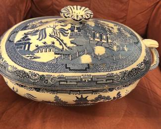 Wedgwood Blue Willow Soup Terrine — This striking Wedgwood soup terrine features the classic Blue Willow pattern, renowned for its intricate blue and white landscape design. Crafted in Etruria, England, this ceramic piece includes a fitted lid with a floral knob and two loop handles for easy serving. Measuring approximately 5.5 inches high, 13 inches wide including handles, and 9 inches deep, it holds ample capacity for elegant table presentation. The terrine is in good condition with some visible age-related wear consistent with vintage Wedgwood pottery. A timeless addition for collectors or those who appreciate fine English china and traditional tableware.