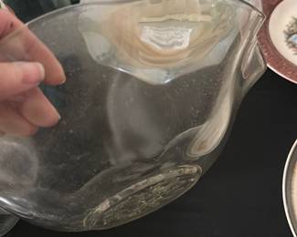 Vintage Clear Floral Pressed Glass Bowl — This vintage pressed glass bowl features a distinctive floral pattern embossed in the center, adding an elegant touch to any table setting. Crafted from clear glass with gently scalloped edges, the bowl is both decorative and functional for serving or display. It measures approximately 9 inches in diameter and 3.5 inches in height, making it a versatile size for various uses. The bowl is in good condition with minor surface wear consistent with age, no chips or cracks are visible. A charming collectible for vintage glass enthusiasts or a stylish accent for your home.