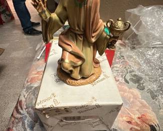 Fontanini by Roman Kneeling Wise Man — This Fontanini by Roman kneeling wise man figurine features hand-painted detail and classic nativity styling, sold in its original box. Made of composite/resin with soft muted colors and gilt accents, the piece captures expressive facial detail and flowing robes. Measures approximately 7.5 inches tall and about 4.5 inches wide with a 4 inch depth, a manageable size for tabletop nativity displays. In good condition with light shelf wear to paint and the original retail sticker on the box; ready to display as part of a holiday scene or collectible Fontanini set.