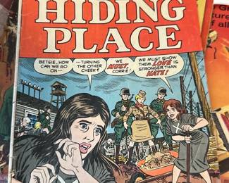 The Hiding Place Comic Book — The Hiding Place comic by Corrie ten Boom is a mid-century Christian-themed comic book with illustrated wartime scenes and moral dialogue. The softcover issue shows interior full-color comic pages and a glossy illustrated cover in red, yellow and blue. Measures approximately 10.5 inches tall and 7.25 inches wide (standard comic size); light wear to cover edges and minor spine creasing but pages remain intact. Good collectible condition for display with expected handling wear and no major tears visible.
