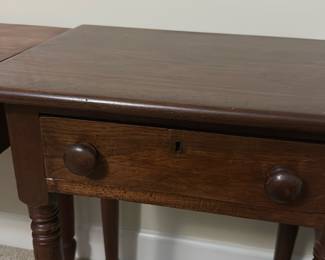 Antique Wooden Side Table with Drawer — This antique wooden side table features a classic single drawer with round wooden knobs and a subtle keyhole detail. Crafted from solid wood, it showcases turned legs and a rich brown finish, perfect for bedroom or living room use. The table measures approximately 28 inches in height, 30 inches in width, and 18 inches in depth, providing a compact yet functional design. It is in good condition with minor surface wear consistent with its age, maintaining its sturdy construction and timeless appeal. Ideal for collectors or those seeking vintage charm in their home decor.