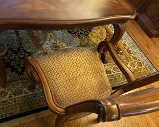 Dining Room Wood Inlaid Table & chairs — This elegant dining room table features a finely crafted wood surface with intricate inlaid diamond patterns. The table is supported by sturdy cabriole legs and comes with matching upholstered armchairs in a beige diamond pattern fabric. Measuring approximately 31 inches in height, 42 inches in width, and 90 inches in length, it offers ample seating for family and guests. The piece is in good condition with minor surface scratches consistent with normal use. Its classic design and quality woodwork make it a versatile addition to any traditional dining space.
