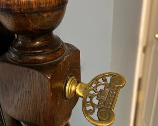 Floor Cheval Tilt Mirror — Freestanding wooden cheval tilt mirror with turned posts and decorative brass tilt keys. Dark stained wood frame with carved pedestal base and original glass, suitable for a bedroom or dressing area. Measures approximately 60 inches tall, 24 inches wide, and 16 inches deep overall; sturdy but shows surface wear and small chips on the base consistent with age. In good, usable condition aside from scuffs and finish loss at feet; brass hardware is intact and functional.