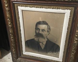 Ornate Oak Framed Portrait — Large framed portrait of a bearded gentleman in an ornate oak and gilt frame; the heavy carved molding and applied gilt ornament give this piece strong Victorian-era character. The portrait appears to be a charcoal or lithograph-style print behind original glass, set in a painted rabbet and decorative gilt liner. Overall substantial size (see dimensions) makes it well suited for a foyer or den; ideal for collectors of period frames or decorative salvage. Frame and print show surface grime, light spotting on the image, and some wear to the gilt and wood consistent with age but no major structural damage.