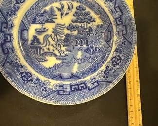 Doulton's Blue Willow Dinner Plate — This charming Doulton's Blue Willow dinner plate showcases the classic blue and white willow pattern that has been beloved for generations. Crafted from fine ceramic, the plate features intricate scenic designs including pagodas, boats, and bridges framed by geometric and floral borders. Measuring approximately 10 inches in diameter, it serves as both a functional dish and a collectible decorative item. The plate is in good condition with minor surface wear typical of vintage use but no visible chips or cracks. Doulton's hallmark indicates quality craftsmanship synonymous with English pottery traditions.