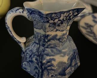 Patent ironstone small picture — This charming Johnson Bros creamer pitcher features a classic blue and white transferware pattern with floral and pastoral motifs. Made of fine china with a distinctive octagonal shape and decorated handle, it adds a vintage English country style to any collection or table setting. Measuring approximately 4.5 inches tall, this piece is sturdy yet delicate, perfect for serving cream or milk. The condition is good with minor signs of wear and no visible chips or cracks. Marked with the Johnson Bros 'Lesley' pattern stamp, it reflects the renowned English pottery craftsmanship known for quality and style.