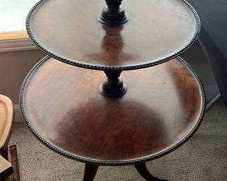 Three Tier Mahogany Serving Stand — This elegant three-tier mahogany serving stand features graduated round trays with decorative beaded edges, ideal for displaying or serving. Crafted from rich mahogany wood, the stand is supported by turned central columns and rests on three carved claw-and-ball feet. It measures approximately 30 inches in height, with the largest tray about 20 inches in diameter and the smallest about 12 inches. The stand is in good condition with some minor surface wear consistent with age and use. A versatile and timeless piece, perfect for formal dining or as a decorative accent.