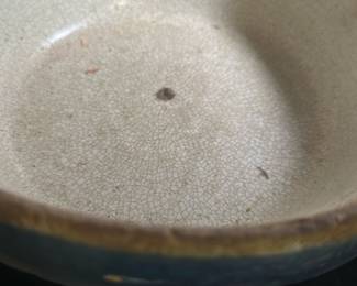 Antique Blue Glazed Ceramic Bowl — This antique blue glazed ceramic bowl features a rustic design with a crackled cream interior and a textured swirl pattern on the base. The bowl displays subtle signs of wear and age, consistent with vintage ceramic craftsmanship. Measuring approximately 3.25 inches in height and 8 inches in diameter, it is a modestly sized decorative or functional piece. The bowl is in fair condition with minor chipping and surface imperfections typical for an item of its age. This piece would be a charming addition to any vintage or collectible ceramic collection.