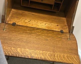 Vintage Oak Writing Desk with Mirror — This vintage oak writing desk features a built-in mirror with a rounded rectangular frame, adding both functionality and charm. The drop-front desk opens to reveal multiple internal compartments and a small drawer, perfect for organizing stationery and writing tools. Measuring approximately 40 inches high, 30 inches wide, and 18 inches deep, it stands on elegantly curved legs that enhance its classic appeal. The desk is in good condition with minor surface wear consistent with age, and the mirror remains intact without cracks. Ideal for a basement room or cozy study, this piece showcases solid oak craftsmanship and a timeless design.