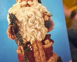Hand Painted Collectable Santa — Hand painted collectable Santa figure in original box, photographed in the deck room. The piece depicts a traditional Santa with sculpted woolly beard, garland and sack of toys; colors include red, cream and green. Boxed item appears in fair condition with visible wear and a torn sticker spot on the top front of the box; figure condition unverified inside. Good estate-sale pick for seasonal decor or a holiday collector looking for an affordable display piece.