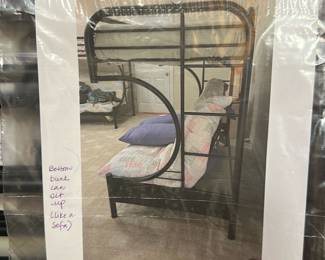 Black Metal Bunk Bed — This sturdy black metal bunk bed frame includes a unique feature where the bottom bunk can sit up like a sofa, providing versatile functionality for a bedroom or guest room. The frame is constructed of durable tubular steel with horizontal slats for mattress support and rounded corner designs for added style and safety. The overall frame measures approximately 64 inches tall, 39 inches wide, and 77 inches long. It is in good condition with no visible damage or wear, and comes with assembly hardware in sealed bags. Ideal for space-saving solutions and multifunctional sleeping arrangements in small rooms.