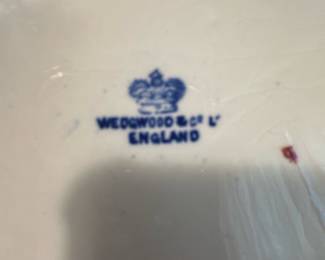 Wedgwood Blue Willow China Plate — This classic Wedgwood Blue Willow china plate features a traditional blue and white pattern depicting a Chinese-inspired landscape. Made in England, this fine china plate is crafted from high-quality porcelain with intricate border designs and central scenic motifs. The plate measures approximately 10.25 inches in diameter, making it an ideal decorative or dining piece. It is in good condition with typical age-related crazing and minor surface wear visible on close inspection. Wedgwood's timeless design and craftsmanship make this plate a valued collectible for both everyday use and display.