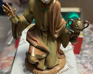 Fontanini by Roman Kneeling Wise Man — This Fontanini by Roman kneeling wise man figurine features hand-painted detail and classic nativity styling, sold in its original box. Made of composite/resin with soft muted colors and gilt accents, the piece captures expressive facial detail and flowing robes. Measures approximately 7.5 inches tall and about 4.5 inches wide with a 4 inch depth, a manageable size for tabletop nativity displays. In good condition with light shelf wear to paint and the original retail sticker on the box; ready to display as part of a holiday scene or collectible Fontanini set.