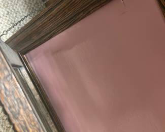 Antique shadow box frame — Attractive wood-grain decorative picture frame with textured carved edging and a dusty rose backing board. The frame appears to be constructed from molded wood or oak-look composite with a glass front and hanging chain on the back. Overall size is moderate and suitable for tabletop or wall display; lightweight and easy to hang. Frame shows light wear to finish and a small tear in the backing paper but glass and molding are intact.