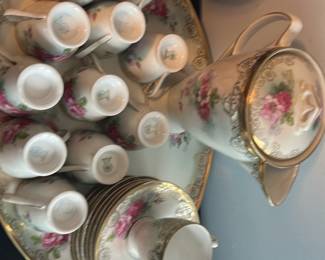 C.T. Altwasser Prussia Porcelain Set — This elegant C.T. Altwasser porcelain coffee set from Prussia features a delicate floral pattern accented with gold trim. The set includes a tall coffee pot with lid, twelve matching cups with handles, and twelve saucers, all resting on a large serving tray. Each piece is marked with the green C.T. Altwasser Prussia hallmark, signifying its classic craftsmanship. The pieces are in good condition with minor wear normal for vintage porcelain, and no visible chips or cracks. This charming set is perfect for collectors or those looking to add a vintage European touch to their dining experience.