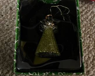 Christmas Angel Glass Ornament — Hand-crafted glass Christmas angel ornament in a glittery green cone dress, presented in its original green decorative box. The ornament features a clear glass head and wings with a gold hanging loop and string, ideal for holiday tree display or seasonal decor. Compact gift-ready piece that appears unused and still nestled in its fitted plastic tray inside the box. In very good condition with no visible chips or cracks; keep boxed for safe storage or gifting.