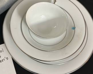 Noritake-Derry White China Set — This elegant Noritake-Derry china set features classic white porcelain with delicate silver rims, perfect for formal dining. The set includes a large oval platter, nine large dinner plates, two soup bowls, eight salad plates, eight cups, eight saucers, and additional serving pieces including cream, sugar, salt and pepper set, butter dish with lid, two oval vegetable bowls, and one divided vegetable bowl. The pristine white finish with silver accents adds a timeless sophistication to any table setting. All pieces are in good condition with minor signs of use consistent with careful everyday dining. Ideal for collectors or those who appreciate fine dining ware from the bonus up room collection.