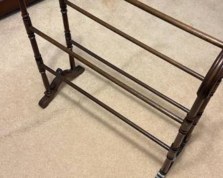 Wooden Quilting Rack — This vintage wooden rack offers a sturdy and practical solution for hanging quilts, towels, or blankets. Featuring turned wood rods with an elegant dark finish, the stand provides multiple horizontal bars for ample hanging space. Measuring approximately 32 inches high, 36 inches wide, and 16 inches long, it fits well in a bedroom or living space. The rack is in good condition with minor surface wear consistent with age but remains fully functional. Its classic design and solid construction make it a timeless addition to any home.