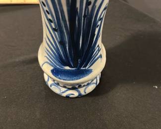 Blue and White Ceramic Vase — This charming blue and white ceramic vase features hand-painted floral designs with elegant lines and decorative patterns. The scalloped top edge and flared form add a distinctive touch to its classic shape, perfect for display or floral arrangements. Measuring approximately 7 inches tall and 3.5 inches wide, it is a lovely accent piece for the blue dishes room or similar decor settings. The vase is in good condition with minor surface wear consistent with gentle use. Its timeless style makes it suitable for both vintage and contemporary collections.