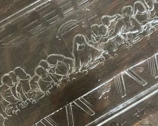 Vintage Glass Last Supper Tray — This vintage clear glass tray features an intricate etched depiction of the Last Supper surrounded by a grapevine border. The detailed scene sits prominently in the center of the rectangular tray with scalloped edges, perfect for serving or display. Measuring approximately 15 inches in length and 9 inches in width, it is a delicate piece suitable for collectors of religious or vintage glassware. The tray is in good condition with some minor surface wear consistent with age but no chips or cracks. A unique decorative item ideal for a bedroom or dining area display.
