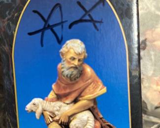 Fontanini Jeremiah Figurine Box — Fontanini Jeremiah from the Fontanini Heirloom Collection (7.5") shown in original retail box printed with 'Fontanini exclusively from Roman, Inc.' The box art shows a kneeling shepherd holding a lamb; box has marker graffiti on front and minor shelf wear. Boxed collectible measures approximately 7.5 inches tall (see dimensions) and is ideal for collectors of Nativity and religious figures. In fair condition due to writing on the box and edge wear; contents not verified — sold as boxed item with visible cosmetic flaws.