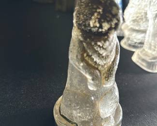 Vintage Glass Rabbit Figurine — This charming vintage glass rabbit figurine offers a delicate and detailed design, capturing fine textural elements and a realistic form. The piece stands on a flat base, crafted from clear textured glass with subtle wear consistent with age. Measuring approximately 5 inches in height and 2 inches in width, this collectible adds a whimsical touch to any shelf or curio cabinet. The figurine shows minor wear but remains intact without chips or cracks. Ideal for collectors of vintage glass animals or unique home decor accents.