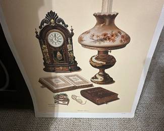 C.W. Vittitow Still Life Print — Decorative still-life print by C.W. Vittitow depicting an ornate clock, oil lamp, books and small objects; signed in the plate area. The print shows warm sepia tones on cream paper and appears unframed in the photos, photographed in the bonus up room. Approximate overall sheet measures noted below; good estate condition with slight curling at edges from storage and minor surface wear visible in photos. Great for framing as vintage-style wall art or part of a gallery grouping.