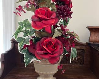 Red Floral Arrangement with Vase — This charming floral arrangement features vibrant red roses and deep burgundy flowers accented by green and variegated leaves, all artfully set in an elegant ivory ceramic vase. The combination of rich colors and naturalistic greenery creates a striking decorative piece suitable for any room. Standing approximately 24 inches tall with a width of 14 inches, it creates a bold floral statement while maintaining a classic aesthetic. The arrangement is in excellent condition with no visible wear or damage. This piece is ideal as an office or home decor accent to add color and style.