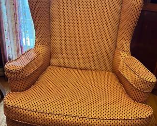 Wingback Chair — This elegant wingback chair features a rich gold patterned upholstery that brings a warm, classic touch to any front room. The piece showcases a high curved back with winged sides and plush armrests supported by carved wooden cabriole legs. Measuring approximately 40 inches tall, 30 inches wide, and 32 inches deep, it provides comfortable seating and stylish presence. The chair is in good condition with minor wear consistent with vintage use, with sturdy frame and well-maintained fabric. Its timeless design and quality construction make it a versatile addition to traditional or transitional home decor.