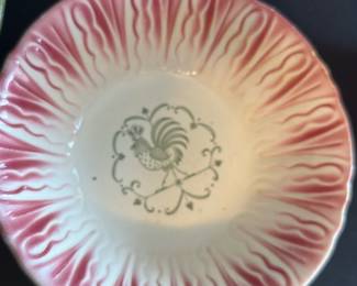 Pink and White Rooster Serving Bowl — This charming serving bowl features a pink and white gradient design with a detailed gray rooster motif at the center. The bowl exhibits a ruffled edge with textured petal-like patterns adding vintage farmhouse appeal. Measuring approximately 2.5 inches high and 10 inches in diameter, it is a versatile piece for serving or display. The bowl is in good condition with no visible chips or cracks. Its nostalgic rooster design makes it a perfect addition to country kitchen decor or collectible ceramic collections.