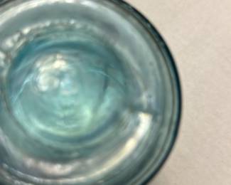 Ball Aqua Glass Jar with Wire Bale — This vintage Ball glass jar features a distinctive aqua blue color and a wire bale closure, typical of early 20th-century canning jars. Made from thick glass, it includes embossed Ball branding and a patent date indicating its collectible nature. Measuring approximately 4 inches in height and 3 inches in diameter, it is a sturdy piece suitable for display or storage. The jar is in good condition with signs of use and some minor wear to the wire bale closure. A great addition for collectors of vintage kitchenware or rustic home decor.