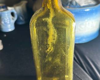 Amber Vintage Glass Bottle with Cork — This amber vintage glass bottle with a secure cork stopper offers a charming and rustic collectible piece. Featuring a rectangular form with gently rounded shoulders and a short neck, the bottle showcases classic craftsmanship with thick amber glass indicative of early to mid-20th century design. Measuring approximately 7 inches tall, 2.5 inches wide, and 2.5 inches deep, it serves as an ideal decorative item or container for liquids. The bottle is in good condition with some surface dirt and wear consistent with age but no visible cracks or chips. Its sturdy glass construction and amber color make it a desirable addition to any vintage or apothecary glass collection.