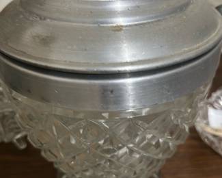 Cut Glass ice bucket Jar with Pewter Lid — Decorative cut-glass biscuit jar topped with a domed pewter-tone lid and finial, perfect for display or storing small treats. The clear pressed/cut glass body features a diamond pattern and sits on a molded circular foot; the metal lid shows a slightly aged patina. Measures approximately 8 inches tall with a 4.5 inch diameter mouth (see dimensions). In good estate condition with light surface wear and minor tarnish to the lid consistent with age.