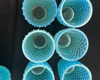 Blue Hobnail Glass Tumbler Set — This charming set includes six blue hobnail glass tumblers, perfect for adding a vintage touch to your drinkware collection. Each tumbler features raised hobnail patterns over frosted blue glass, typical of mid-century decorative glassware. The tumblers measure approximately 4.5 inches in height with a 3-inch diameter, making them ideal for serving cocktails or water. These glasses are in good condition with no visible chips or cracks, showcasing their sturdy vintage craftsmanship. Their vibrant blue color and textured design make them a standout addition to any table setting or glass collection.