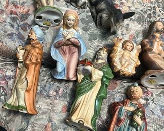 Glazed Ceramic Nativity Figurines — Set of glazed ceramic nativity figurines featuring Mary, baby Jesus, three wise men and animal figures in soft pastel and earth tones. Each piece is hand-painted with a glossy glaze and modest detailing; ideal for tabletop or creche display in a seasonal décor collection. Individual figures vary but average roughly 4–7 inches tall; set is lightweight and easy to arrange for holiday display. Overall good condition with light surface wear and minor glaze imperfections consistent with prior use; no major chips visible in photos.
