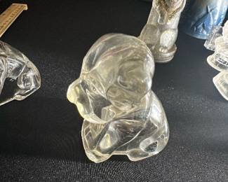 Clear Glass Puppy Figurine — This charming clear glass puppy figurine adds a whimsical touch to any collection or display. Crafted from translucent glass, it features smooth contours and detailed facial features capturing the playful essence of a puppy. Measuring approximately 3 inches tall and 2.5 inches wide, it is a delicate decorative accent perfect for shelves or desks. The figurine is in good condition with no visible chips or cracks. Ideal as a collectible or a gift item for animal lovers.